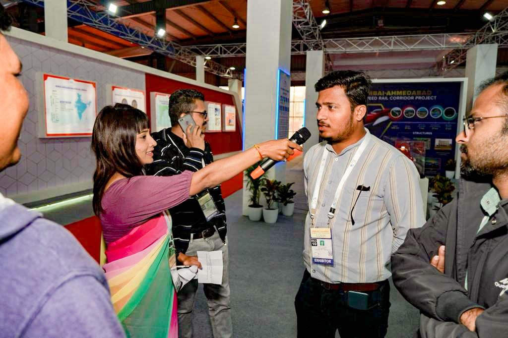 વાઇબ્રન્ટ ગુજરાત 2024 દરમિયાન NHSRCL સ્ટોલ પર ભાગલેનારાઓ ઇન્ટરેક્ટિવ ક્વિઝ ગેમમાં ભાગ લેતા